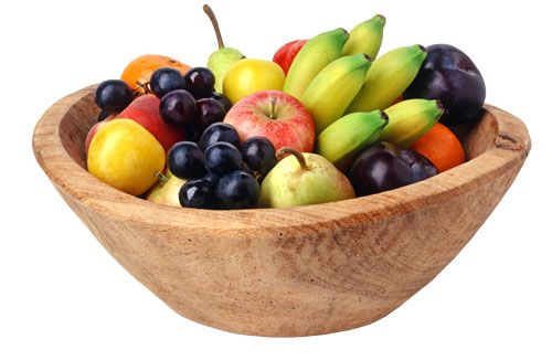Holzschale gefüllt mit verschiedenen Früchten wie Bananen, Äpfeln, Trauben und Pflaumen