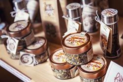 Verschiedene verpackte Teeprodukte in Dosen und Tüten auf einem Holzregal