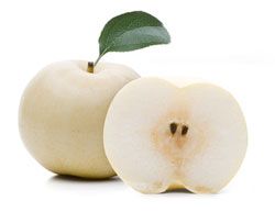 Weiße Birne mit grünem Blatt und eine halbierte weiße Birne mit sichtbaren Kernen